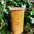 Bamboo cup with a textured top against a green leafy background