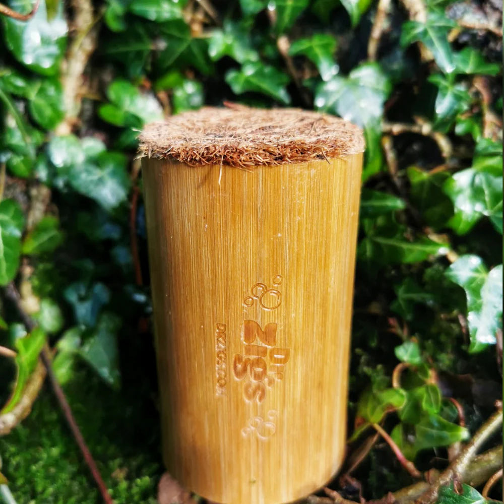 Bamboo cup with a textured top against a green leafy background
