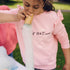 Child blowing large tube of foam bubble from a bamboo cup