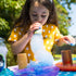 Child playing with bubble solution outdoors, creating a large tube of bubble foam