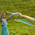 Person blowing large soap bubbles in a grassy field