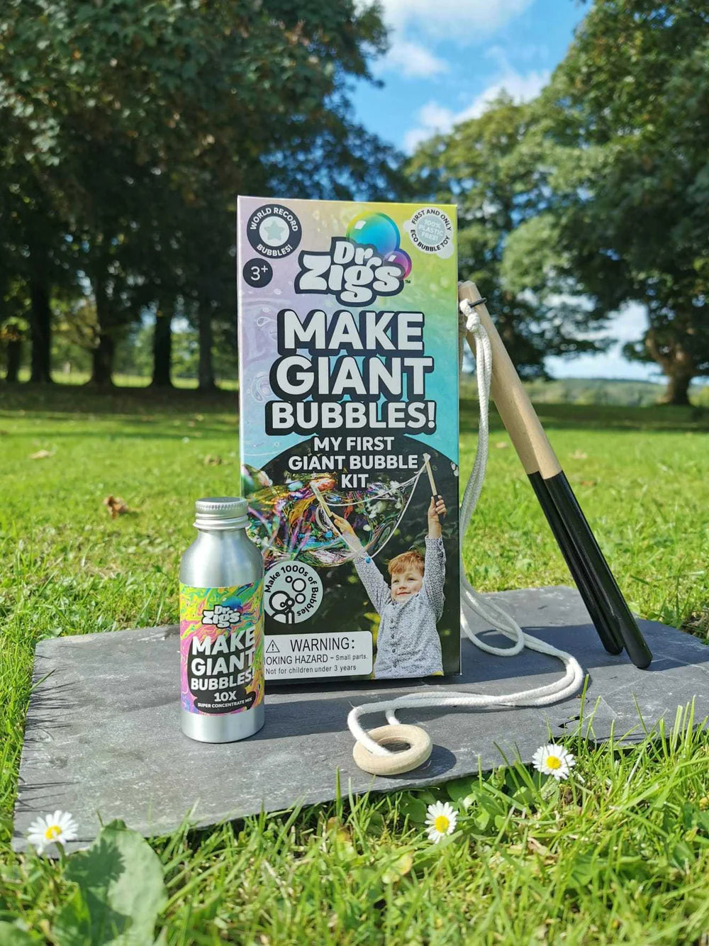 Dr. Zigs bubble kit with bottle and wand on a wooden board outdoors