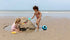 Two children playing with sand toys on a beach.