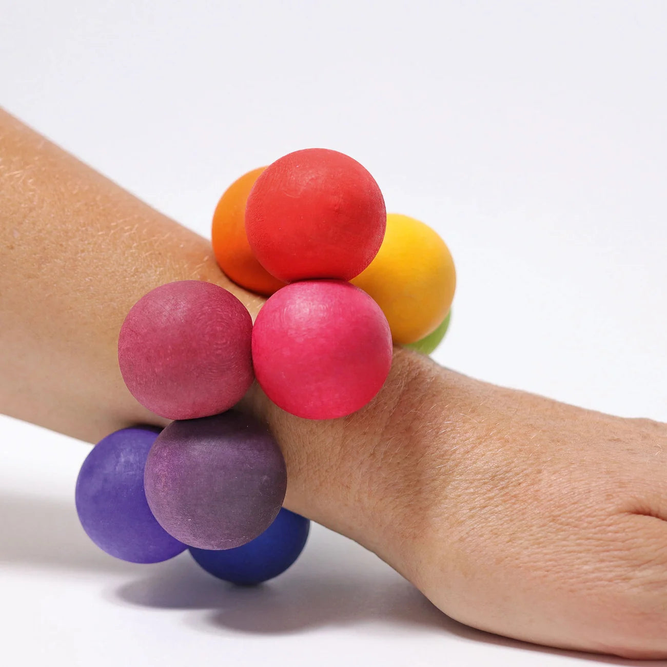 Colorful stress ball on a wrist against a white background