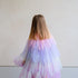 Child wearing a pastel-colored tulle dress with a star pattern against a plain background