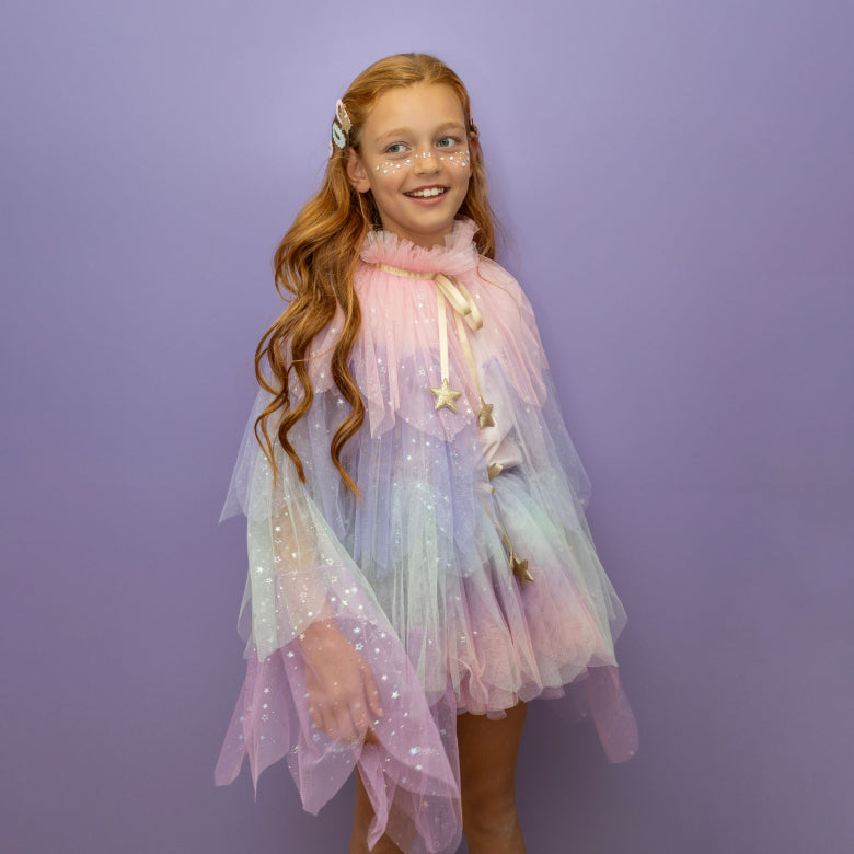 Young girl wearing a colorful, sparkly dress against a purple background