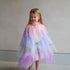 Young girl wearing a colorful fairy costume against a plain background